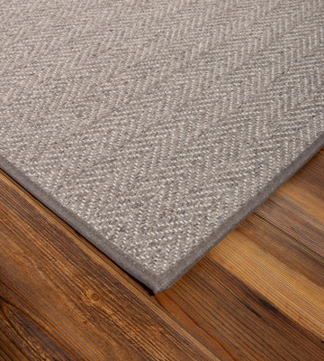 Grey wool stair runner installed on carpeted staircase